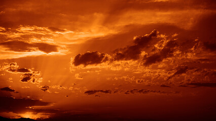 Golden sunset. Evening sky with clouds. Dark orange brown. Fire, explosion, blaze, lightning. Dramatic skies background with space for design. Awe, epic, majestic, fantasy.