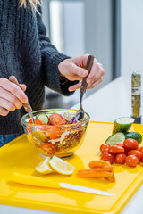 woman stirring salad at home, closed shot