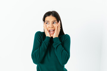 Frightened young woman screams clutching her face