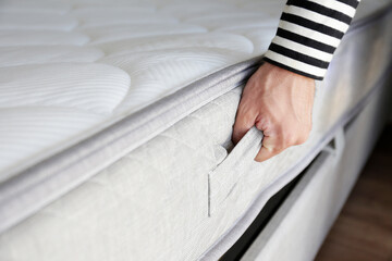 New bed delivery and assembly service concept. Cropped shot of male worker's hands in process of...