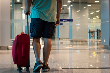 Joven turista caminando por zona de embarque de aeropuerto, dirigiendose a su próximo vuelo
