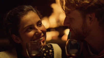 Couple talk drink wine on date closeup. husband wife smiling relax by fireplace