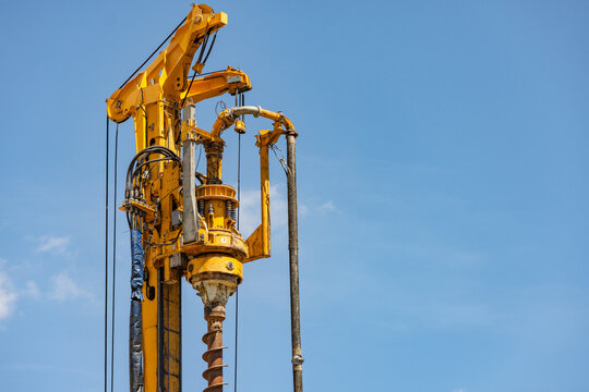 Top of a yellow vertical drilling machine against blue sky