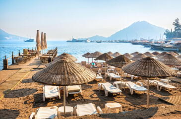 Sunbeds and umbrellas on the beach by the sea, Marmaris, Turkey