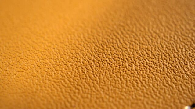 Belt on a white background. Slow macro dolly texture of women's leather belt. Slide shot of a yellow leather belt, close-up view.