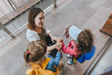Happy smiling woman teacher greeting elementary school students