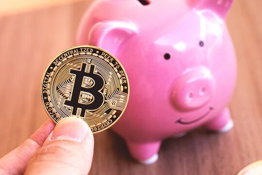 Bitcoin - BTC. Um homem segurando em sua m&atilde;o uma moeda dourada de Bitcoin. Criptomoedas, moeda virtual, forma de pagamento e investimento.