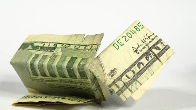 Slide shot of a detailed macro texture of the US dollar bill. Slow dollar shot of a damaged banknote on a white background. Fiat money concept. Torn and crumpled banknote.