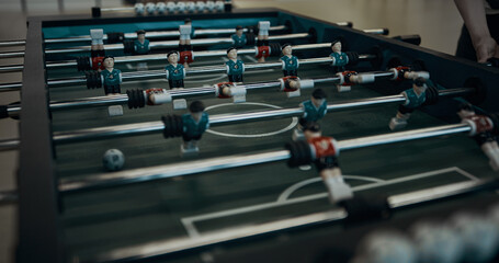 Closeup foosball game table with miniature plastic figures. Teen entertainment.