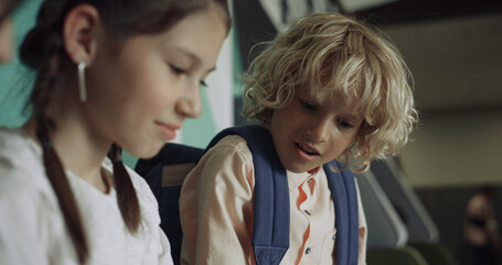 Active kids have fun on school break. Serious brunette girl and boy close up.