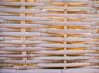 Texture and background of twig weaves. Woven bamboo fence with seamless pattern. Handmade work.