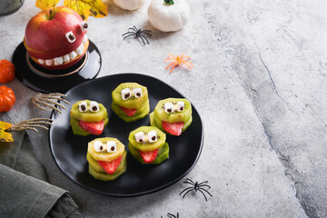 Spooky green kiwi monsters for Halloween. Healthy Fruit Halloween Treats. Halloween party kiwi,...