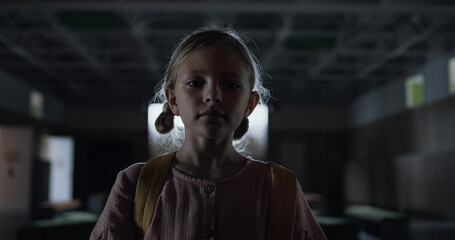 Schoolgirl walking dark hallway alone. Diverse students playing in hall shadow.