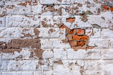 old brick painted wall with cracks