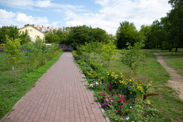 Beautiful path in the park named after the 30th anniversary of the Komsomol of Omsk in summer