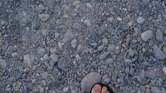 A close-up on the feet of a man walking on the beach. Nice, France, the 3rd August 2022.