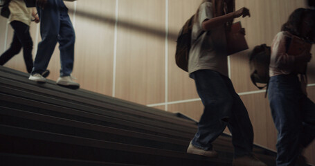 Group teenagers running downstairs school corridor. Children stepping stairway.
