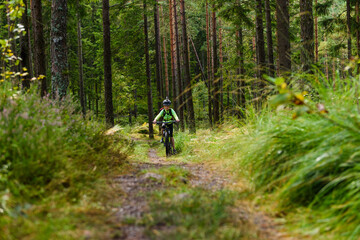 Naklejka premium Young boy cycle mountain bike in forest