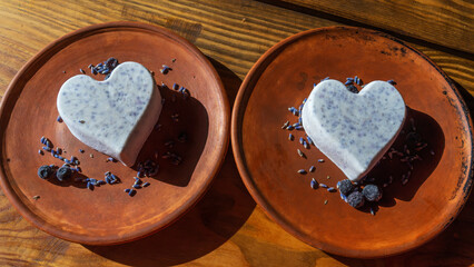 Homemade lavender ice cream in in the shape of a heart in rural clay plate decoration blueberry....
