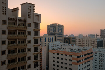 Fototapeta na wymiar Balcony view of generic apartment buildings in the residential neighborhood of Al Qasimia in Sharjah, United Arab Emirates. Urban scene at sunset.