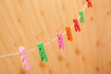 Colorful cute clothespins on rope, abstract vintage background	with different colors