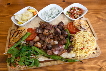 Beef steak grill with rice pilaf, fried potatoes, grilled pepper and tomatoes.Mix Platter with Beef rips, Cutlets, Potatoes and Sauces.
