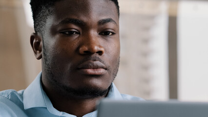 Close up exhausted young millennial african businessman overworked man massaging dry irritable eyes...
