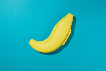 Top view of plastic yellow banana case with sharpen shade isolated on blue  background.