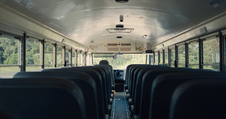Interior empty school bus closeup. Rows seats inside safety public transport. - obrazy, fototapety, plakaty