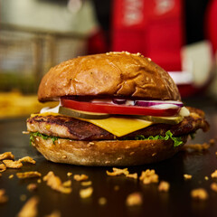 Tasty cheeseburger on a citchen background. Burgers with meat, tomato, cucumber, onion and cheese.