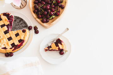 Plate with tasty American cherry pie on white background. Top view. Copy space