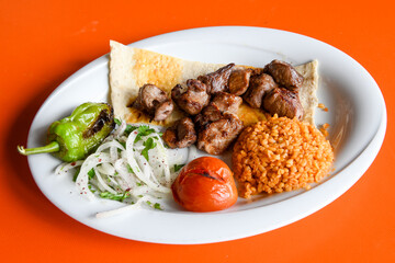 Beef steak grill with rice pilaf, fried potatoes, grilled pepper and tomatoes.Mix Platter with Beef rips, Cutlets, Potatoes and Sauces.