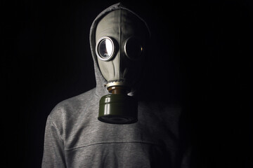 A man in a gas mask, on a black background. Ecological catastrophy.  Stalker. 