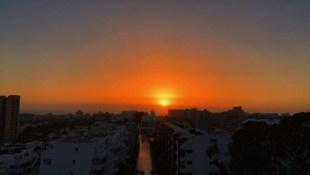 4K aerial footage of a vibrant sunset in the sky in Los Cristianos town in Tenerife, Spain