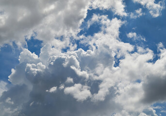 blue sky with clouds. thick white and gray clouds against the background of a blue sky in the daytime and bright. moving pile of smoke