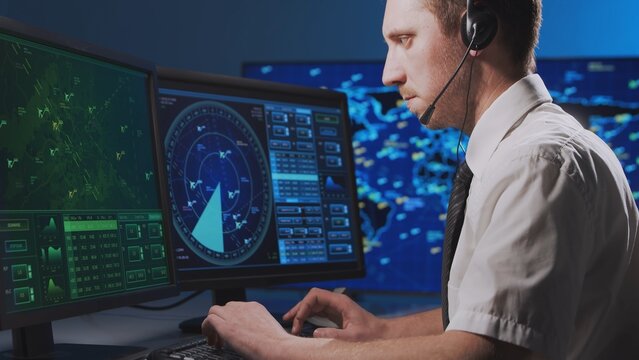 Workplace of the professional air traffic controller in the control tower. Caucasian aircraft control officer works using radar, computer navigation and digital maps. Aviation concept.