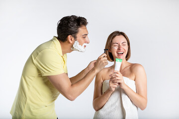 Young happy cheerful couple laughing after shaving and having a bath isolated on white background