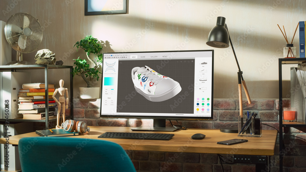 Poster Desktop Computer Monitor Standing on a Table with 3D Design Softwear Processing a Model of Shoe. Cozy Empty Loft Apartment with Big Window with a Lamp, Notebook and Headphones on the Table.
