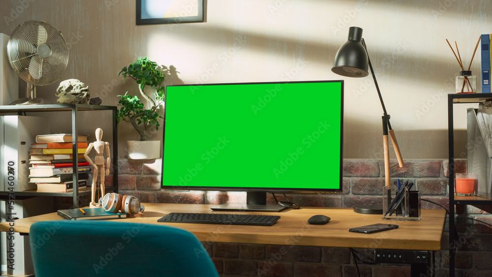 Poster desktop computer monitor standing on a desk with a green screen chromakey mock up display. cozy empt