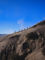 A group of climber hike down Mount Bromo crater rim.