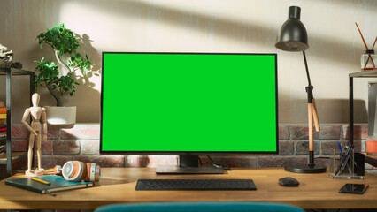 Desktop Computer Monitor Standing on a Table with a Green Screen Chromakey Mock Up Display. Cozy...