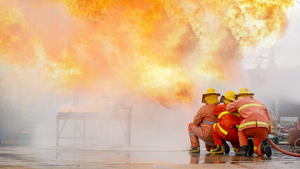 Fireman,Firefighter training Firefighters using water and fire extinguishers to fight the flames in...