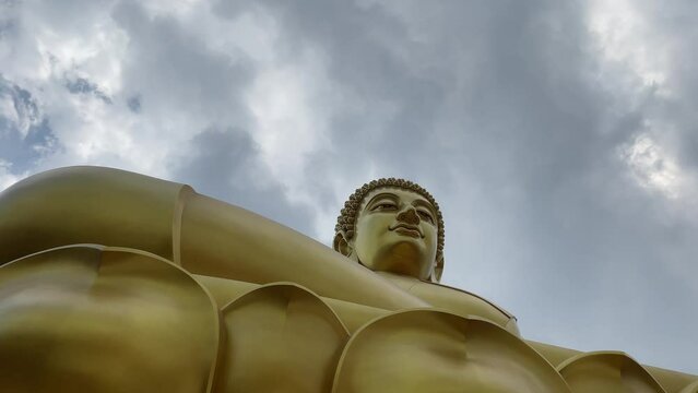 Giant golden buddha statue at Wat Paknam Phasi Charoen, famous buddhist temple with blue sky background - day. BANGKOK, THAILAND 