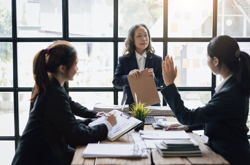 Business meeting. The senior manager talks to employees in the conference room and discuss company project development strategies during the meeting.