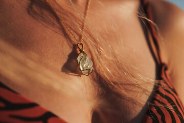 Natural stone necklace on young woman's neck, natural stone necklace,  in the sunlight, selective...