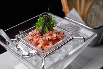 Salmon tartar in ice with toast. selective focus