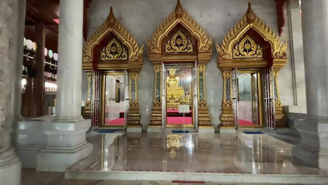 Walking at Wat Paknam Phasi Charoen temple. POV shot walking forward see temple architecture interior