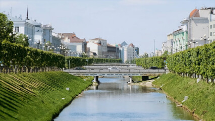 Beautiful view of city with green trees and white houses along the river. Stock footage. Romantic houses along the river canal in the old city of Middle Europe.