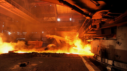 Hot steel being poured to the chute at the steel plant, heavy industry concept. Stock footage. Molten steel production in electric furnaces.