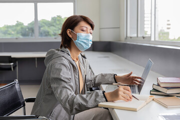 Beautiful woman wearing a face mask read book in library.